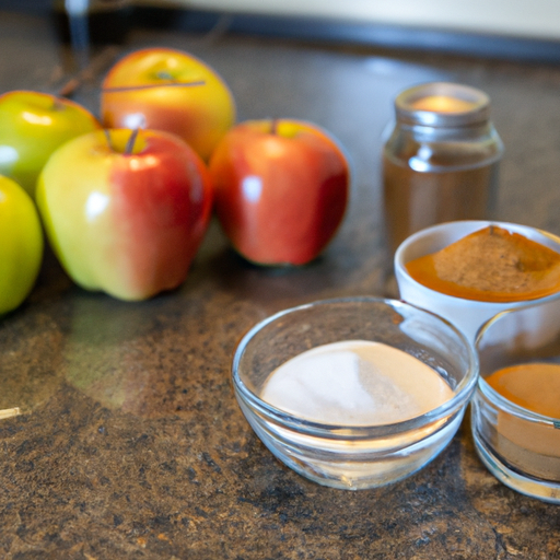 Fresh apples, sugar, cinnamon, and other ingredients laid out on a kitchen counter